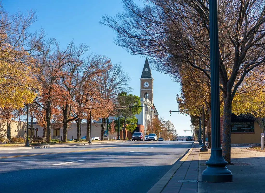 Coldwater-OH-Scenic-View-of-Fall-Colored-Trees-Along-a-Main-Street-in-Coldwater-Ohio-with-a-Church-Visible-in-the-Background-Against-a-Blue-Sky