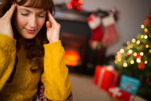 Redhead getting a headache on christmas day at home in the living room