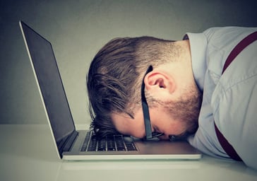 businessman head on keyboard waiting for computer laptop to start bored tired