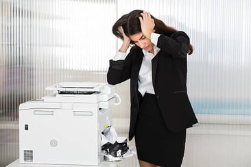irritated businesswoman frusturated with printer in office stressed hands on head