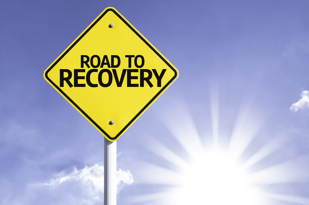 Road To Recovery road sign with sun background-1-1